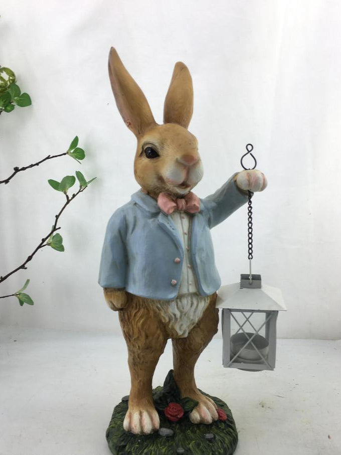 Decorative rabbit figurine holding a lantern on a white background